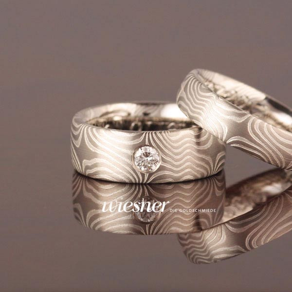 Bagassa Trauringe in Mokume Gane Technik mit einem großen Diamanten