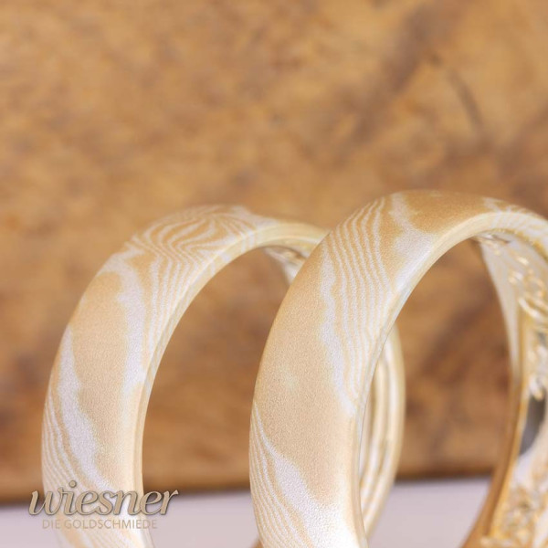 Nahaufnahme der marmorierten Maserung der Paraiso Mokume Gane Ringe aus Gelbgold und Silber