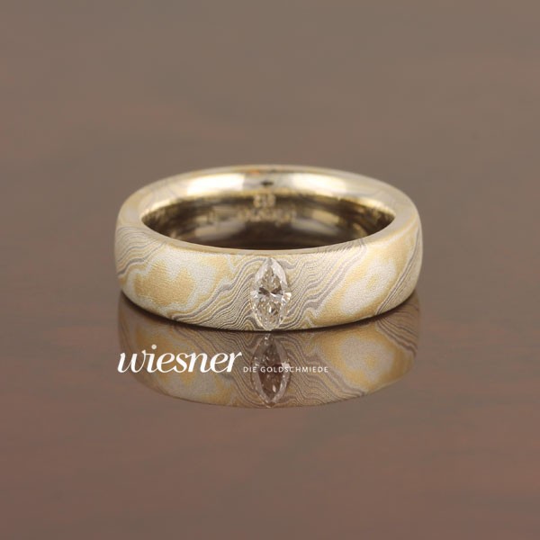 Engagement ring with navette cut diamond 0.25 carat in mokume gane
