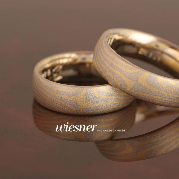 Mokume Gane Trauringe Abura in Weißgold und Gelbgold geschmiedet.