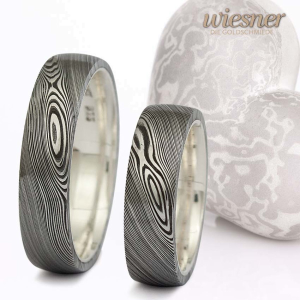 Damascus Steel Rings with wood grain pattern and silver inner ring.