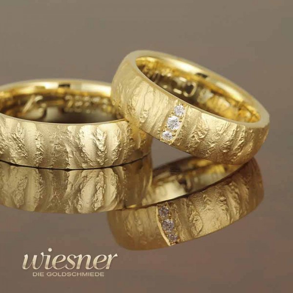 Gerstner Trauringe in Gelbgold mit raw pattern und Diamanten